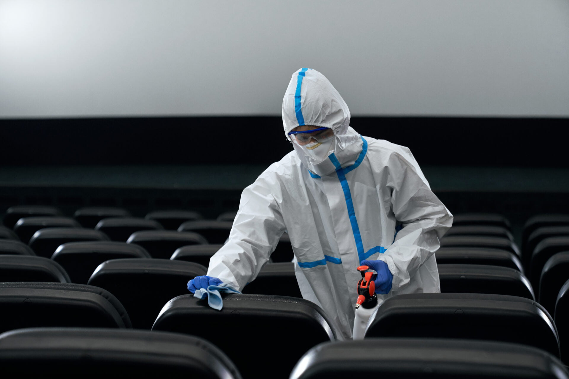 Man in protective suit disinfect cinema hall.